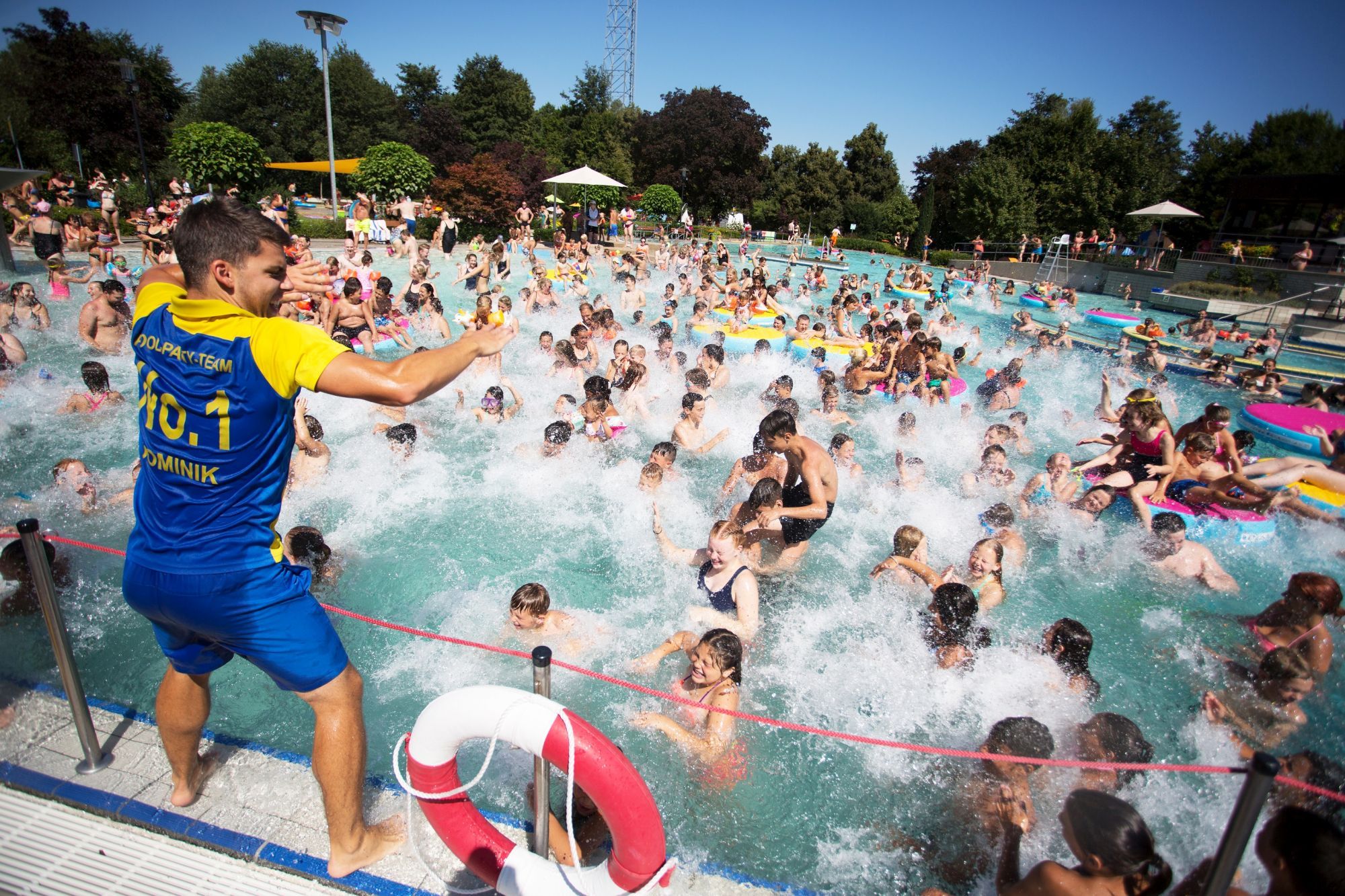 Badegäste feiern bei einer Pool-Party im Freibad.