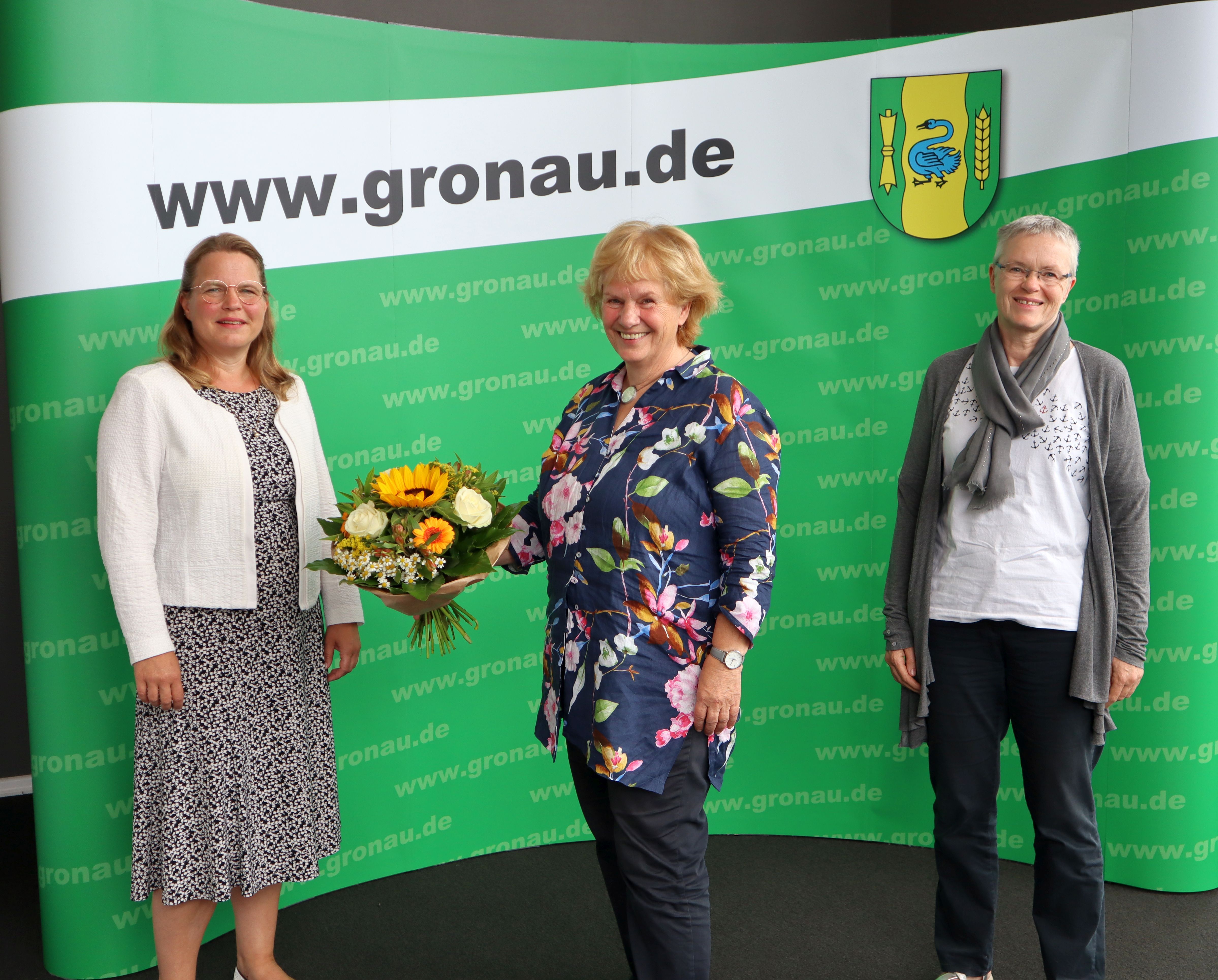 Erste Beigeordnete Sandra Cichon mit Beate Hollands-Lohölter und Elke Liening vor der Fotowand der Stadt Gronau