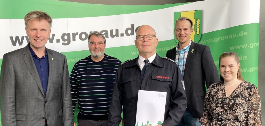 Klaus Gerick mit dem Bürgermeister Rainer Doetkotte und weiteren Beschäftigten der Stadt Gronau 