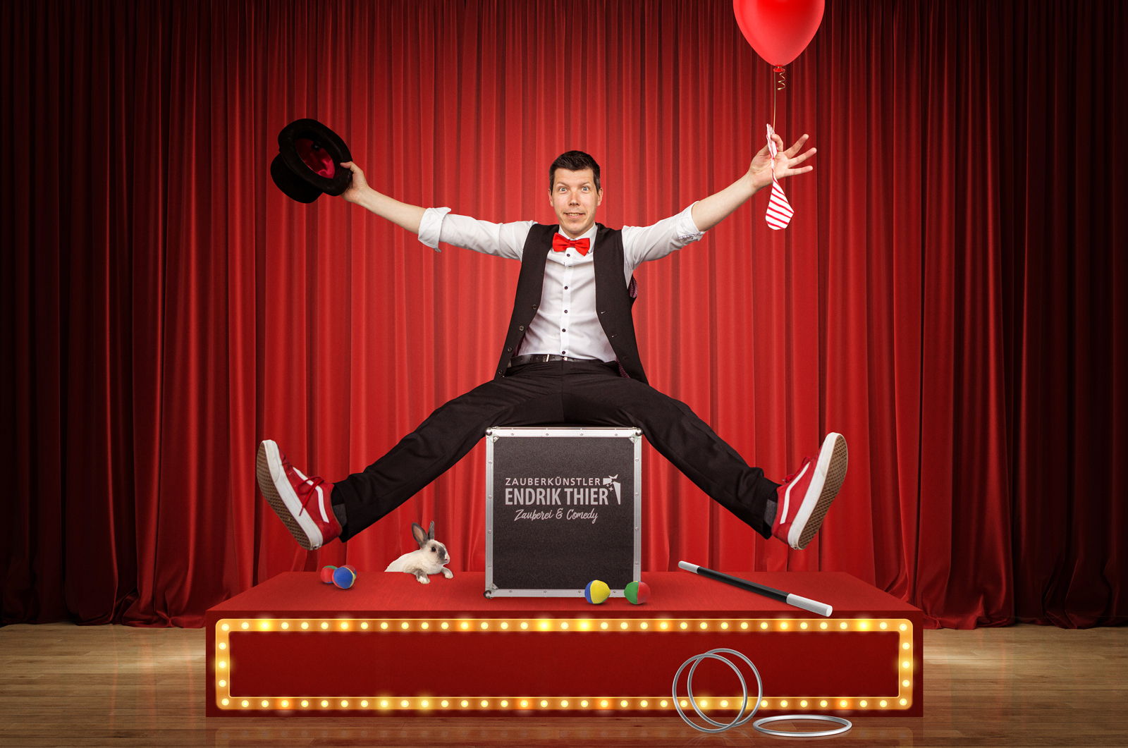 Zauberer auf der Bühne vor einem rotem Vorhang