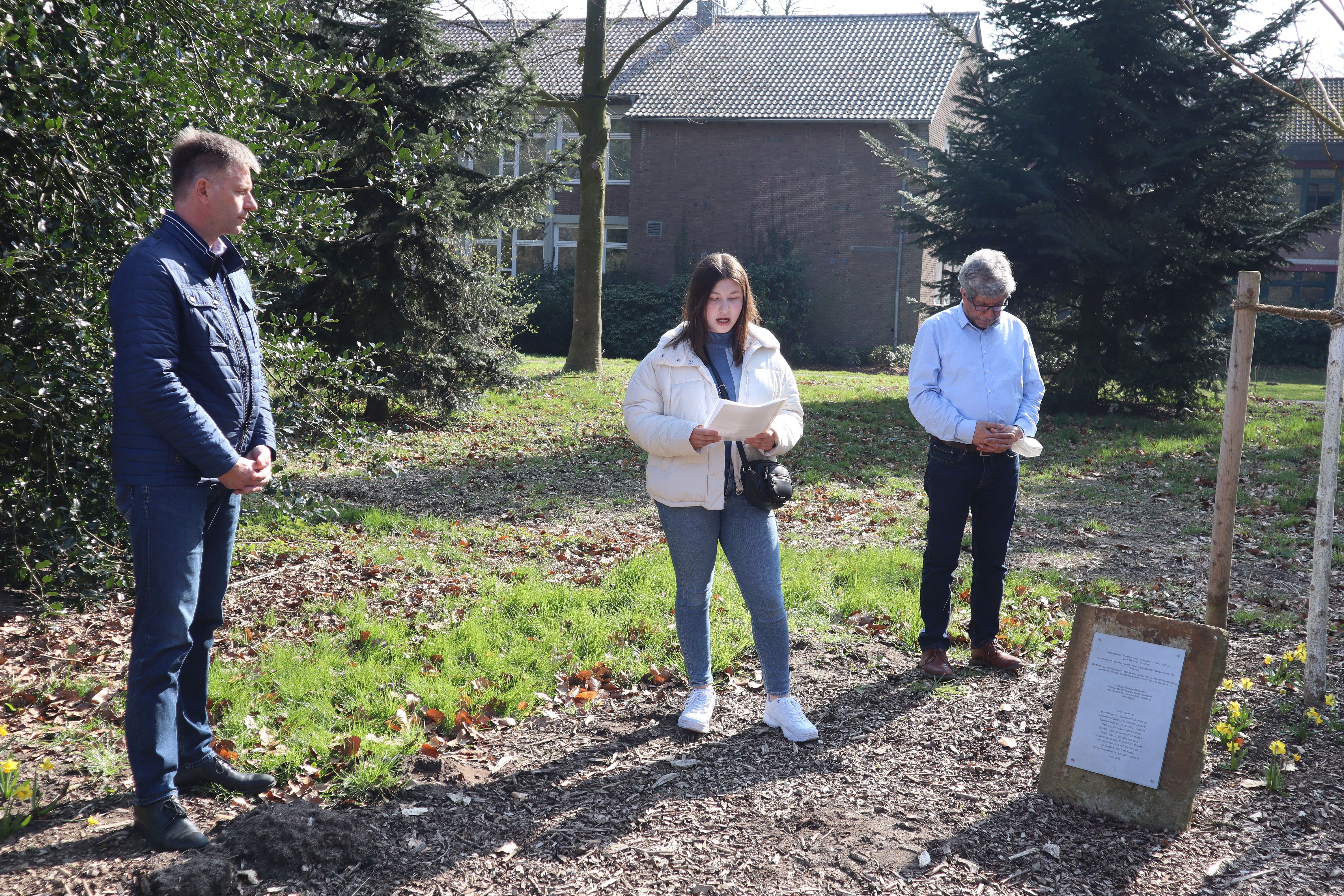 Bürgermeister und Integrationsbeauftragter sowie eine Schülerin an der Gedenkstätte 10 + 1 im Gronauer Stadtpark