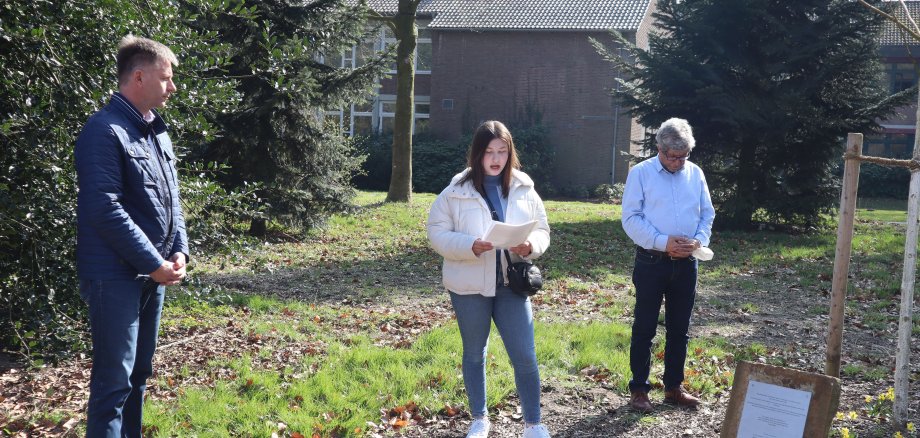 Bürgermeister und Integrationsbeauftragter sowie eine Schülerin an der Gedenkstätte 10 + 1 im Gronauer Stadtpark