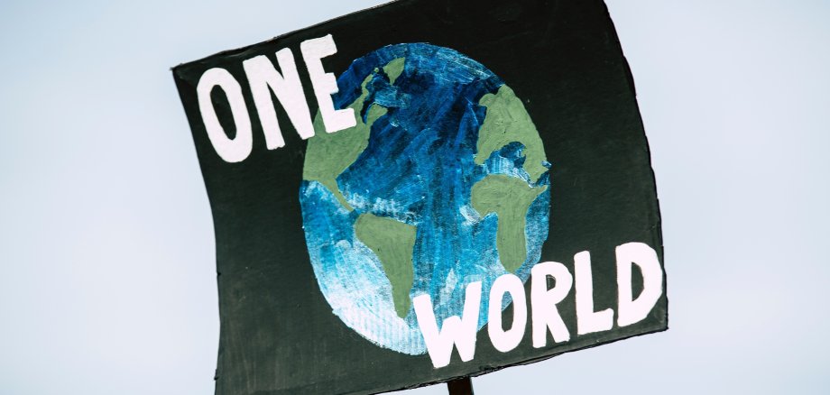 Plakat mit der Weltkugel und der Aufschrift One World