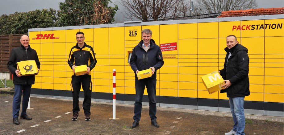 Vier Personen vor einer DHL Packstation