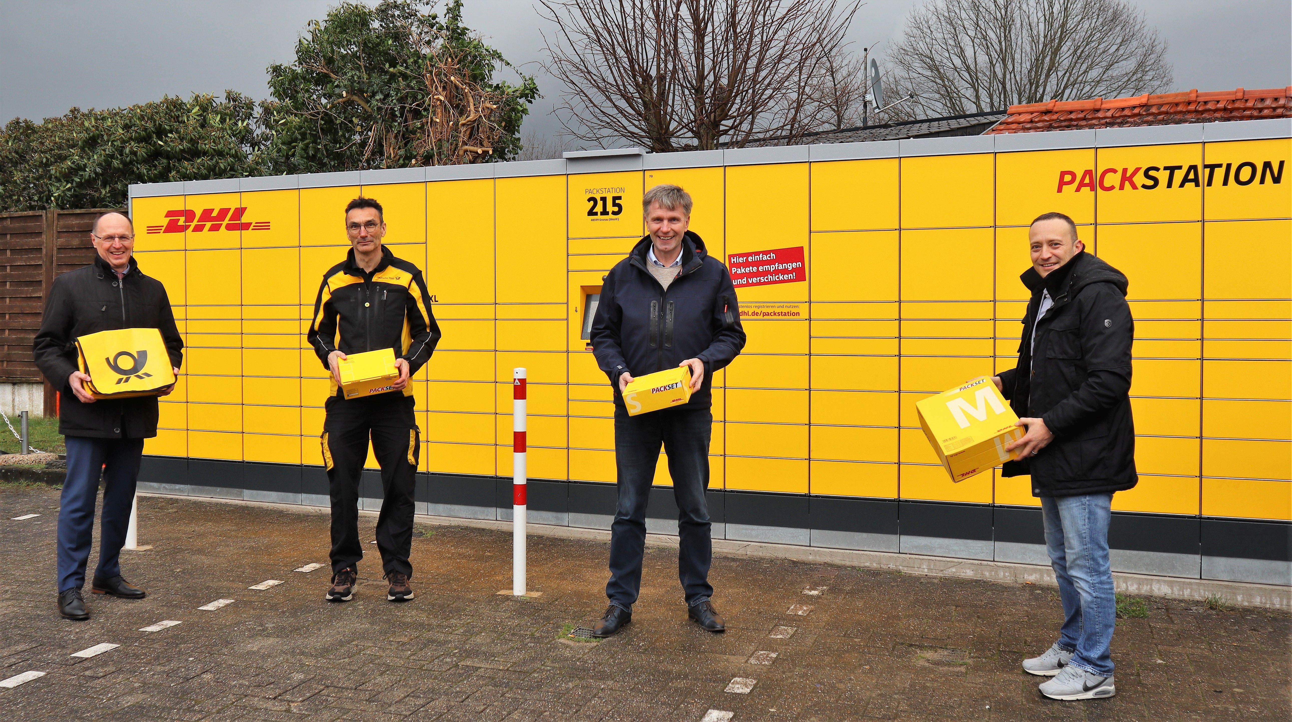 Vier Personen vor einer DHL Packstation