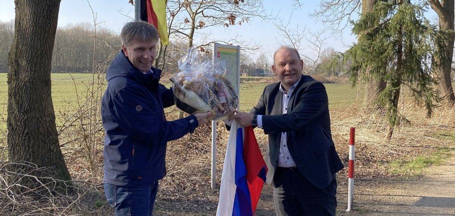 Bürgermeister Doetkotte und Wethouder Nijhuis mit der deutschen und niederländischen Flagge am Smokkelpad