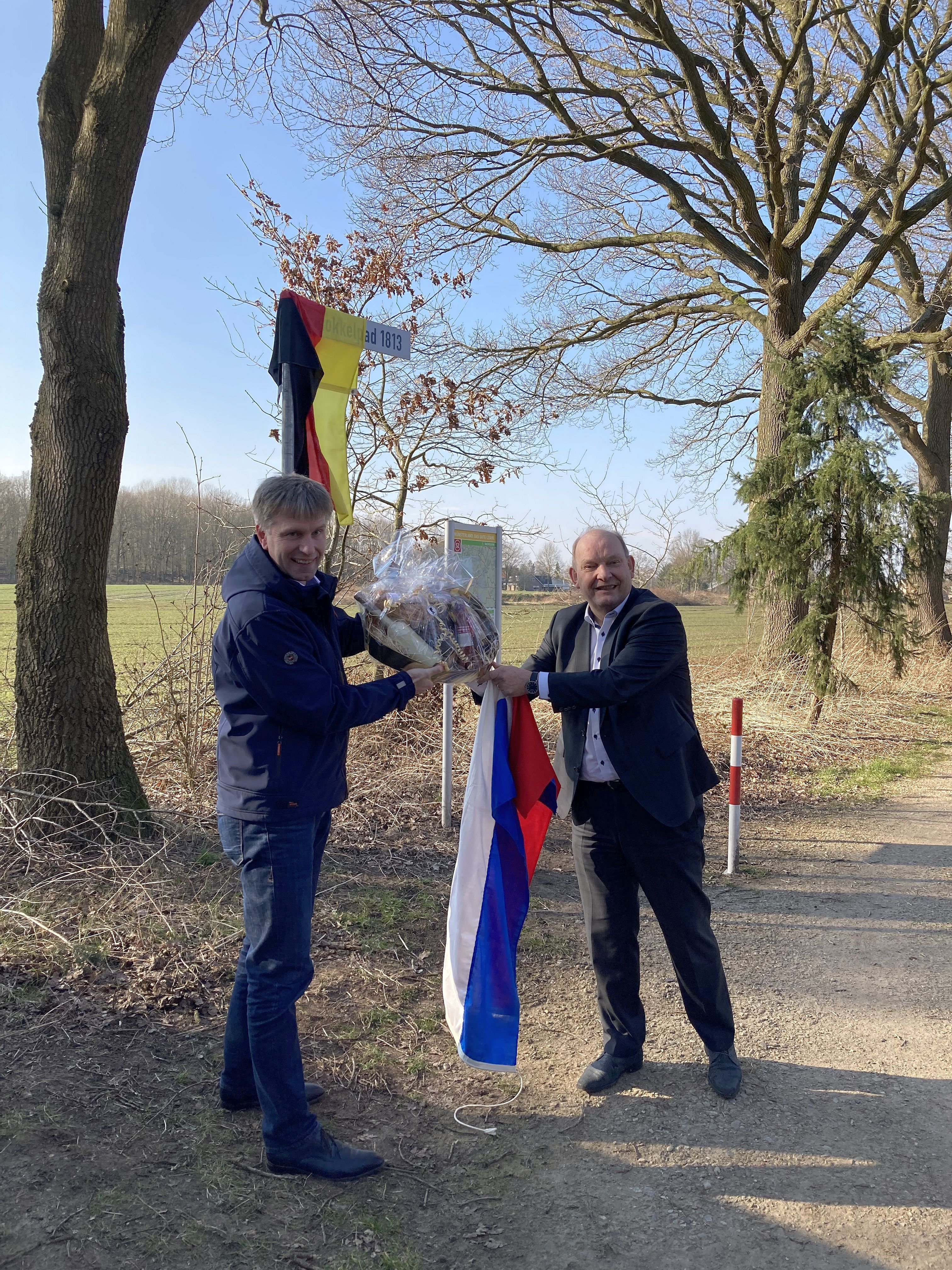 Bürgermeister Doetkotte und Wethouder Nijhuis mit der deutschen und niederländischen Flagge am Smokkelpad