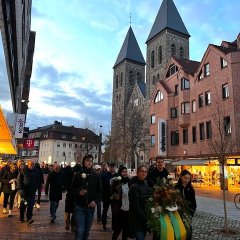 Die Beteiligten gehen durch die Innenstadt zum Denkmal