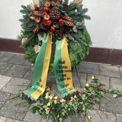 Ein Blumenkranz mit der Aufschrift "im stillen Gedenken, Schülerinnen und Schüler der Euregio Gesamtschule. Davor liegen Rosen.