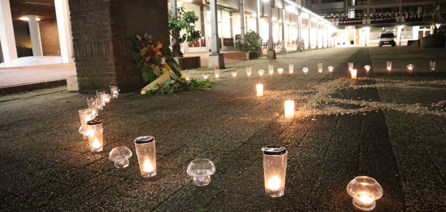 Der Blumenkranz und Kerzen vor dem Denkmal am Kurt-Schumacher-Platz