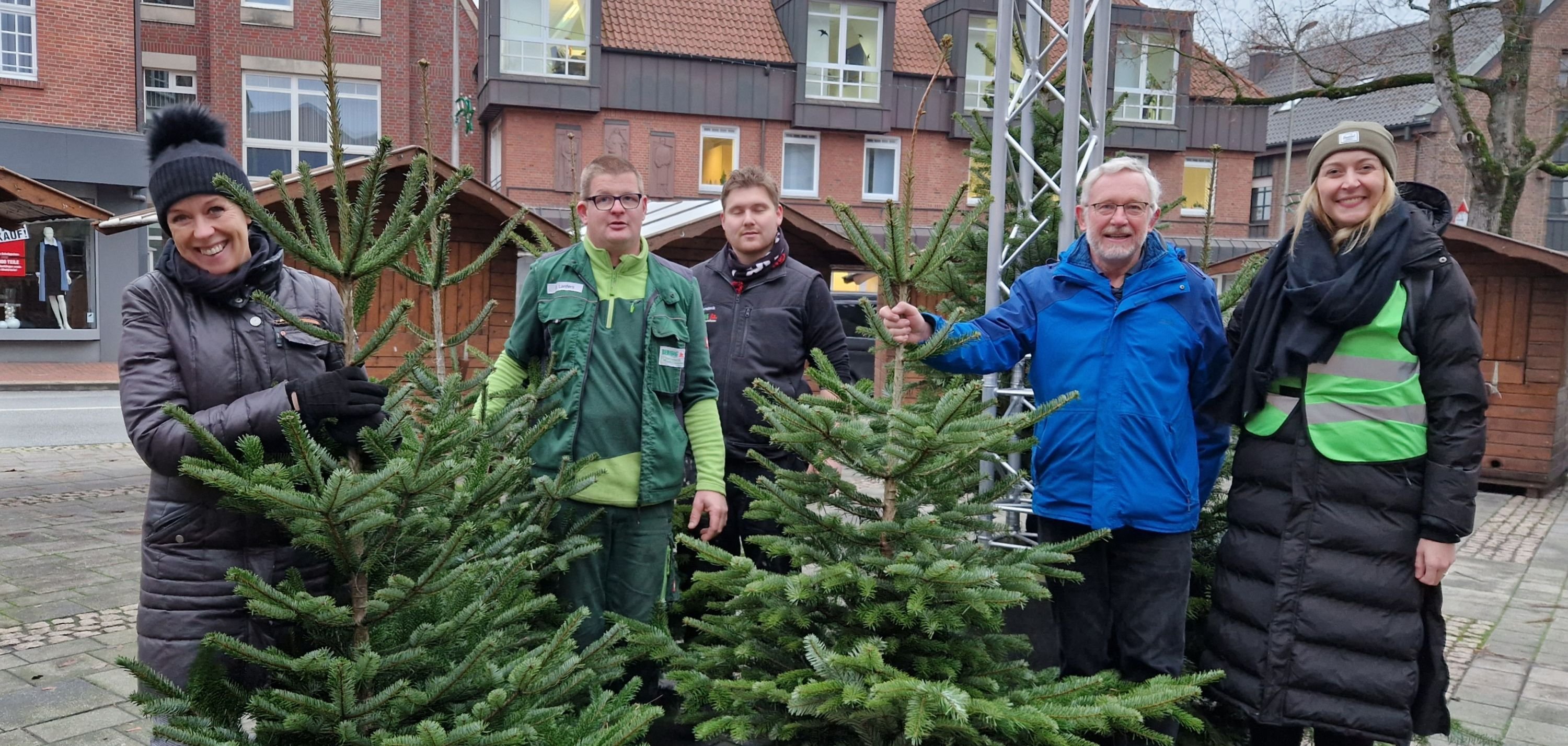 Elke Rinke (Stadtmarketing Gronau), Mitarbeiter der Firma Berning Garten- und Landschaftsbau), Georg Gartmann von der Gronauer Tafel und Katharina Terhan (Stadtmarketing Gronau) mit Tannen