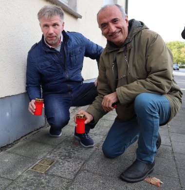 Bürgermeister Rainer Doetkotte und Sahin Aydin stellen Kerzen an den Stolpersteinen ab