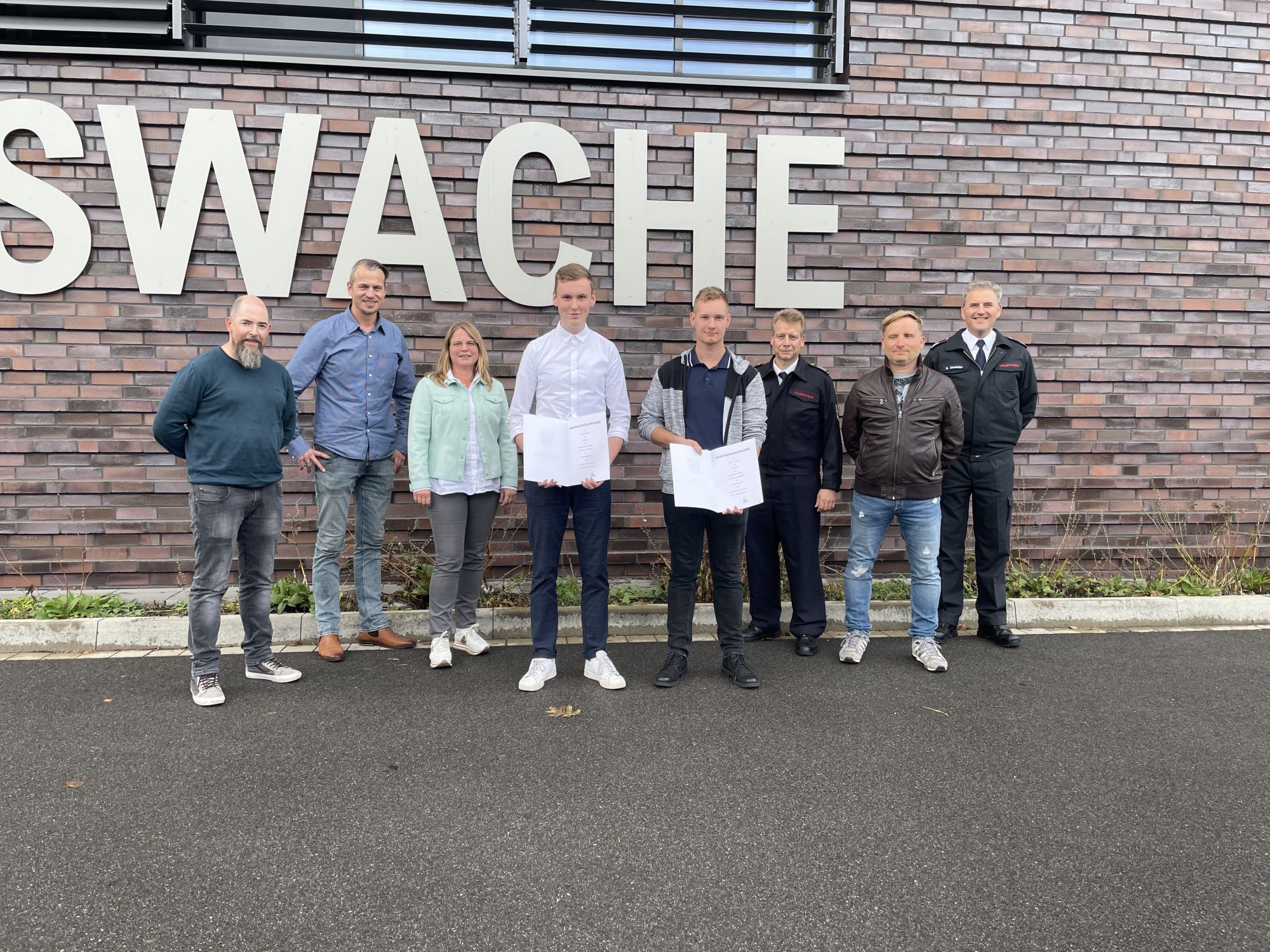 Ausbildungsleitung Martin Klümper und die Erste Beigeordnete Sandra Cichon beglückwünschen Andre Wellers und Jannik Schroven.