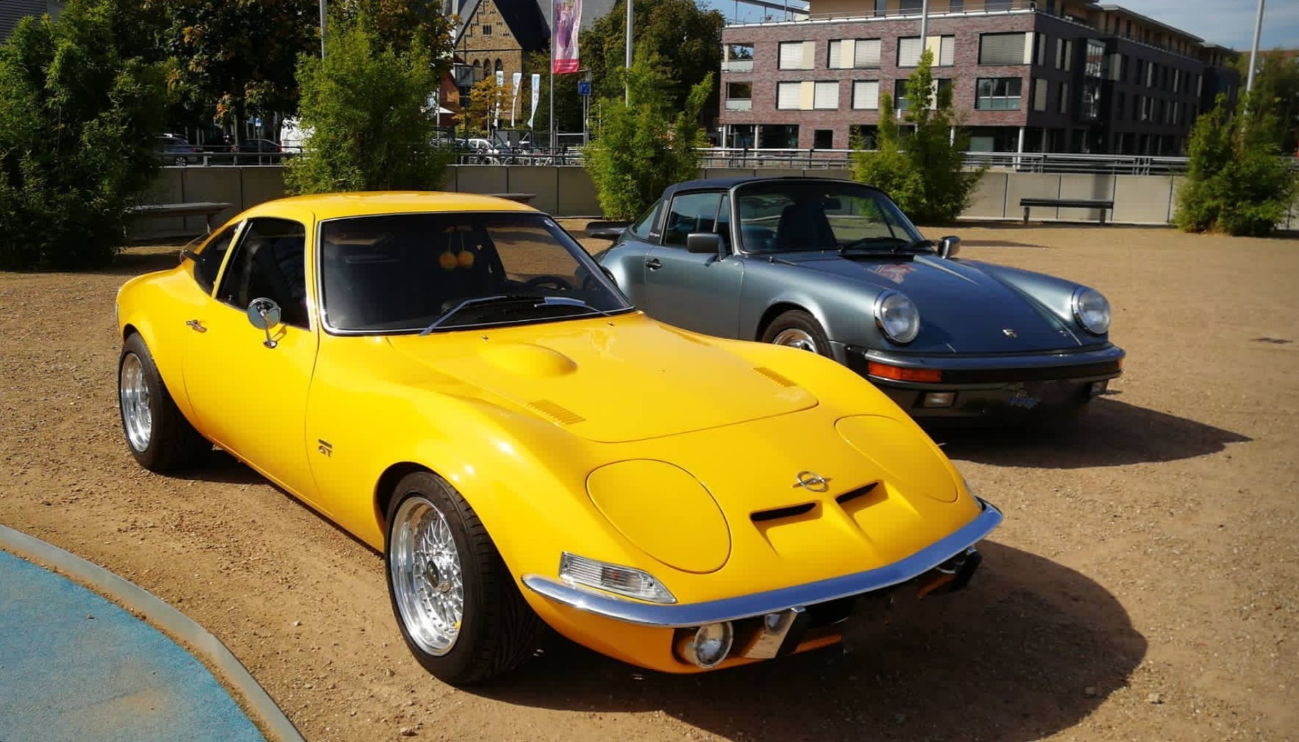 Ein gelber und grauer Oldtimer auf einem Parkplatz