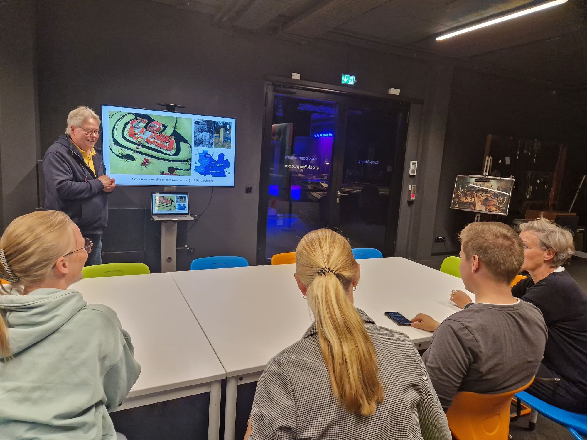 Klaus Wiedau mit Teilnehmenden der Stadtführung im Sitzen.