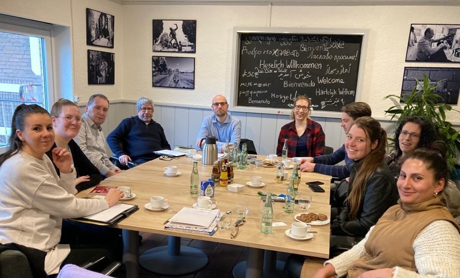 Gruppe von Menschen beim Informationsaustausch im Haus der Begegnung