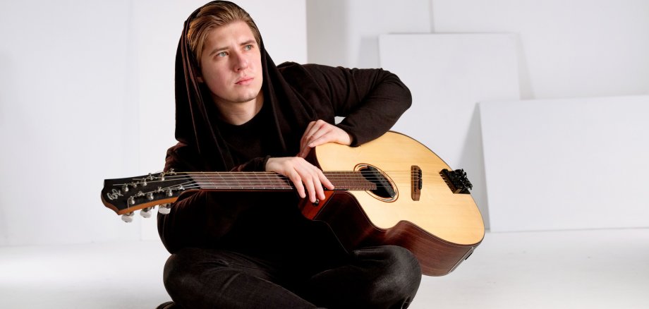 Alexandr Misko mit einer Gitarre.
