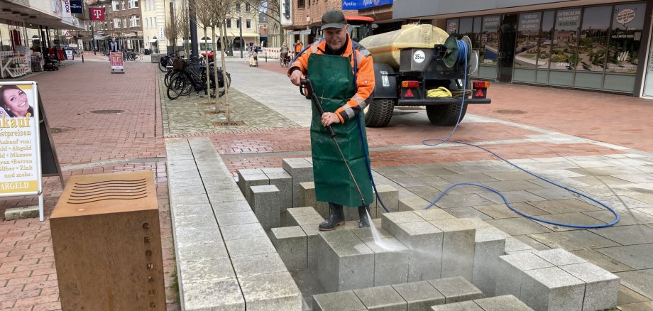 Ein Mitarbeiter reinigt den Brunnen in der Innenstadt.