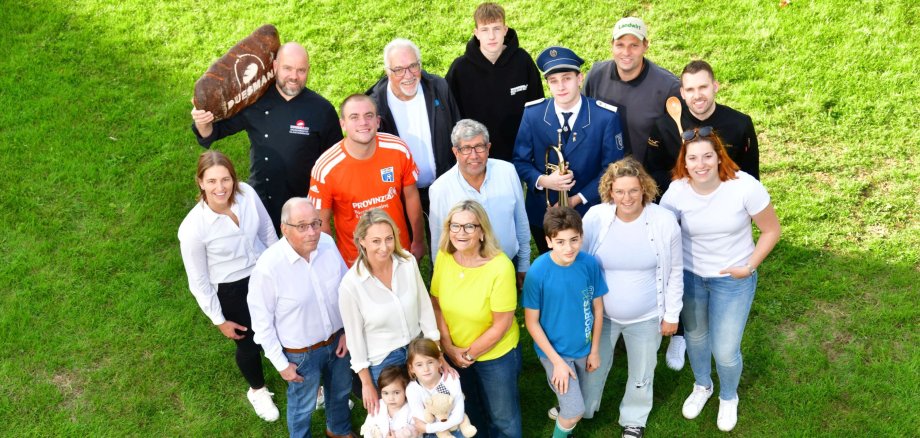 Verschiedene Personen aus Gronau stehen auf einer Wiese.