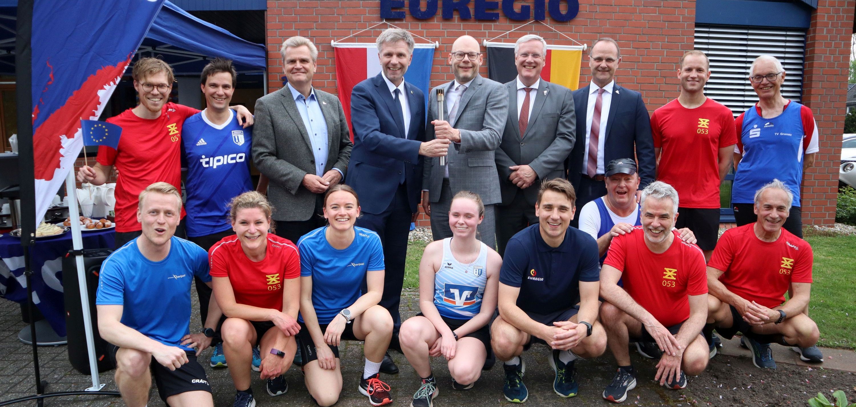 Die Läufer:innen mit dem Präsidenten des EUREGIO-Rates, Rob Welten, dem Bürgermeister der Stadt Gronau, Rainer Doetkotte, dem Bürgermeister der Gemeente Enschede, Roelof Bleker, dem niederländischen Kommissar des Königs, Herrn Andries Heidema, sowie dem Geschäftsführer der EUREGIO, Christoph Almering.