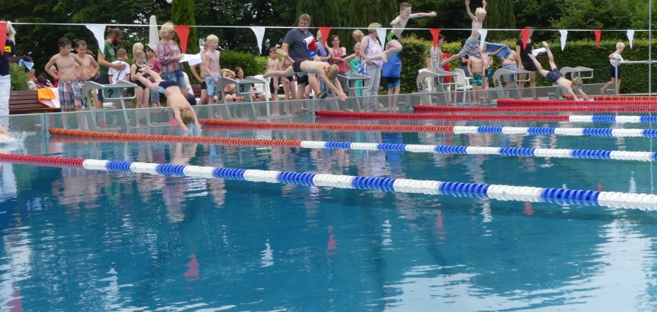 Kinder beim Schulschwimmen im Freibad.