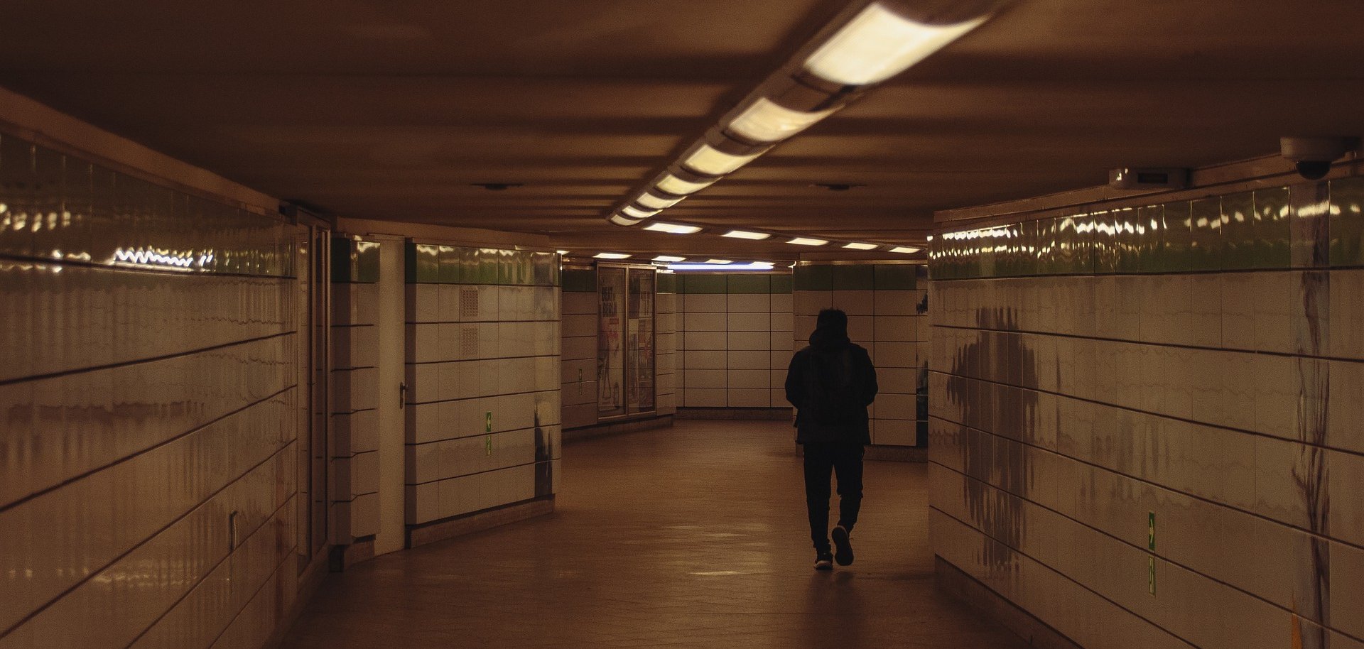 Ein Mann geht durch eine Unterführung.