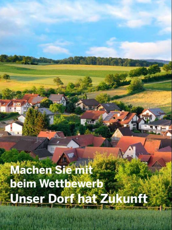 Ein strahlend blauer Himmel eine Grüne Landschaft mittendrin ein paar Häuser. 