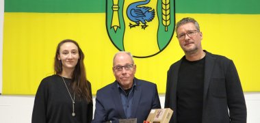 Alexandra Bosch, Werner Hölscher und Bernd Bosch im Ratssaal vor dem Wappen der Stadt Gronau