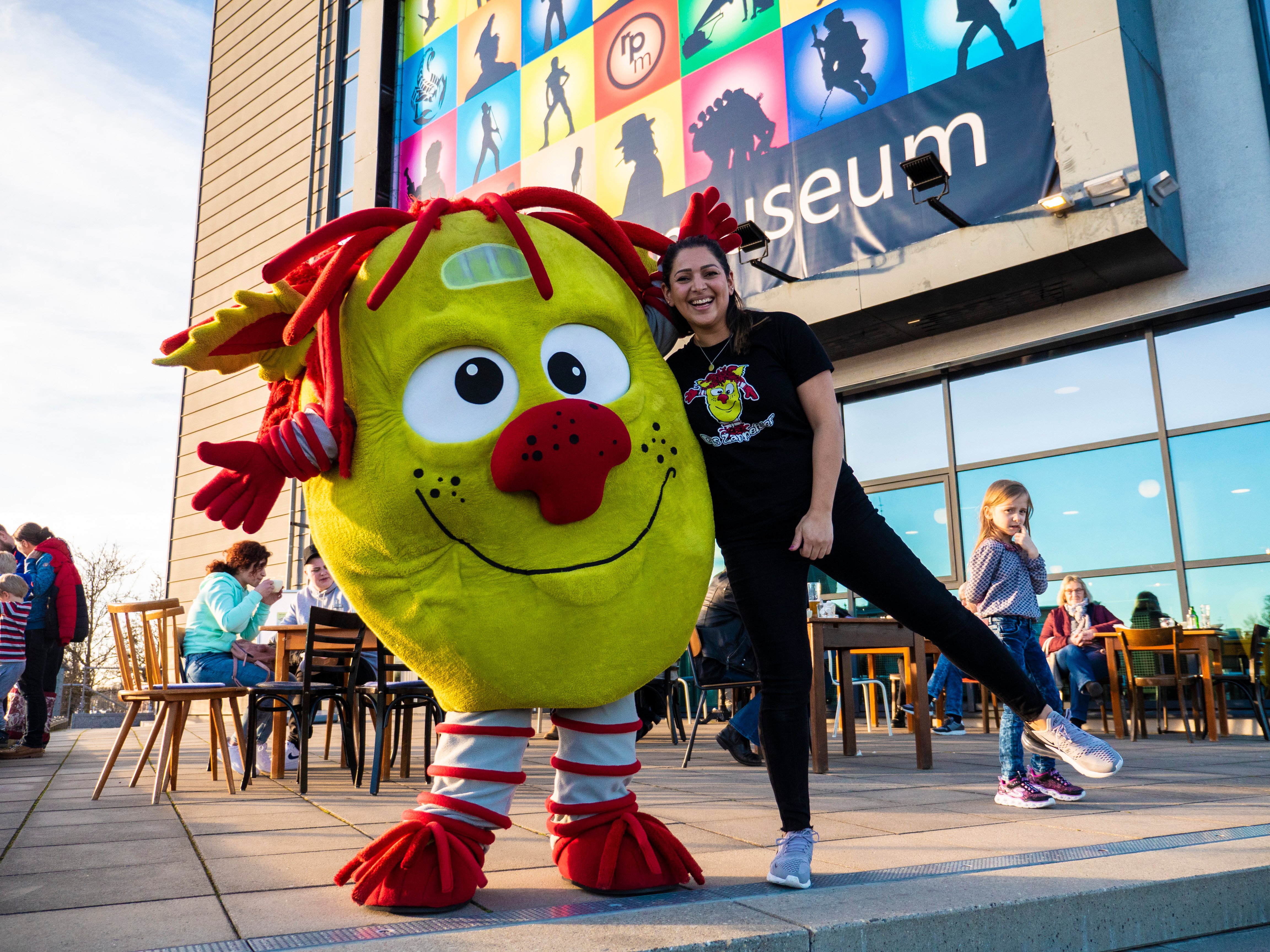 Das Zappeltier neben einer Frau vor dem rock'n'popmuseum.