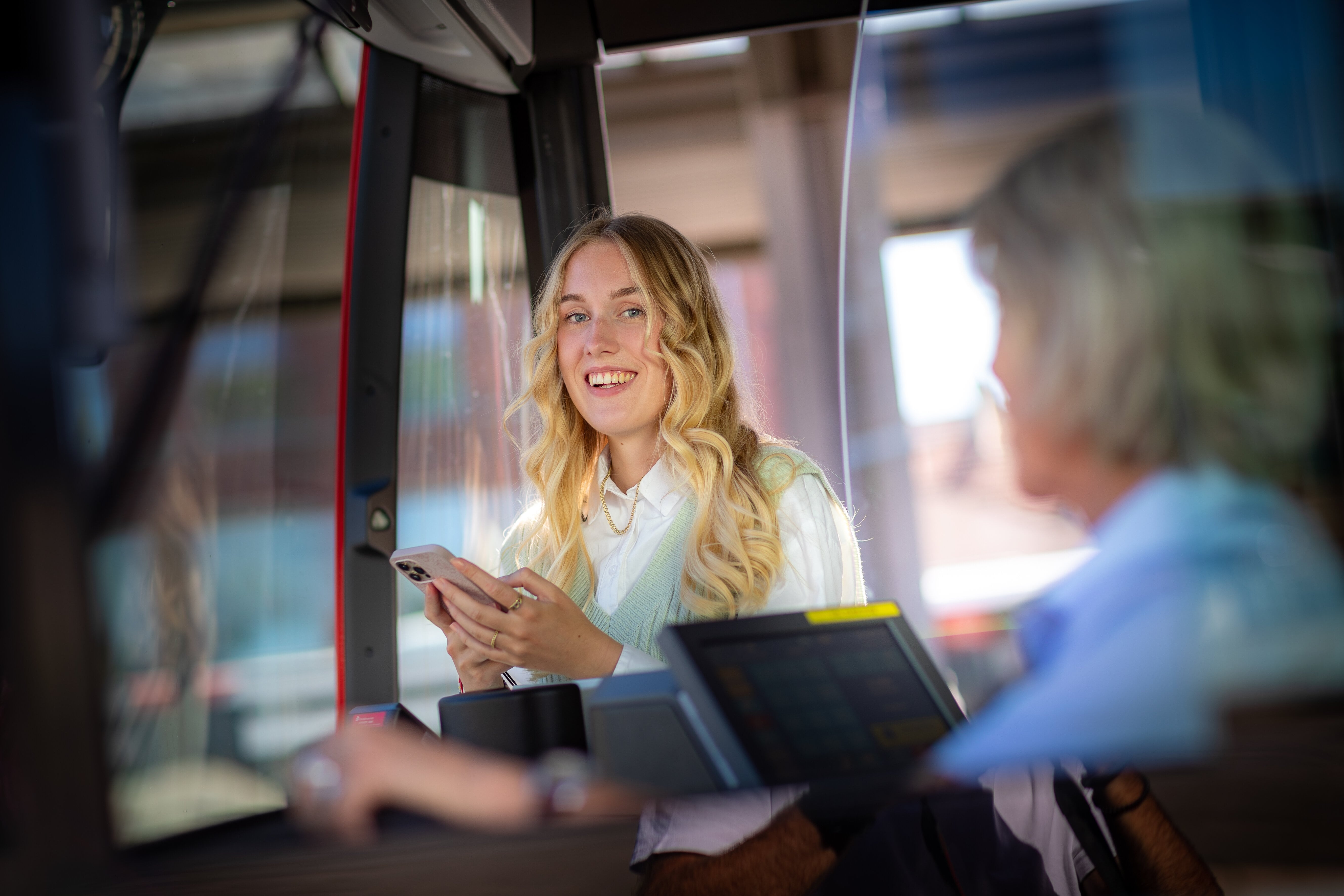 Ein junge Frau nimmt am Handy an der Online-Umfrage zur Bus&Bahn im Münsterland-App (BuBiM-App) teil.