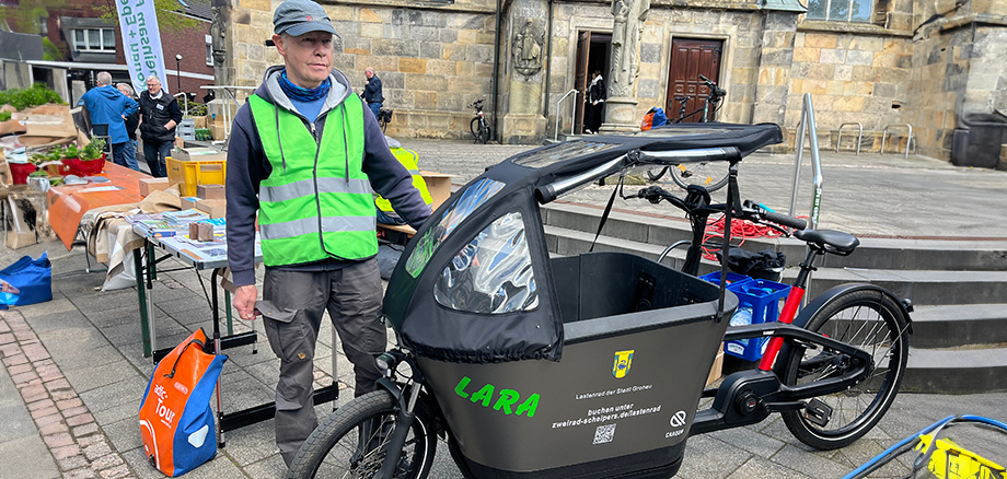 Fahrradbeauftragter Hermann Nieratschker und das Lastenrad LARA stehen auf dem Kirchplatz in Epe