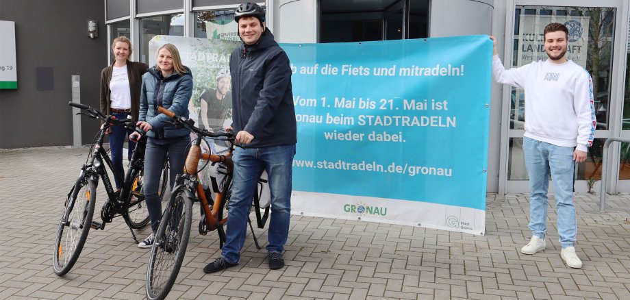 Vier Mitarbeiter:innen der Stadt Gronau machen Werbung für das Stadtradeln 2024