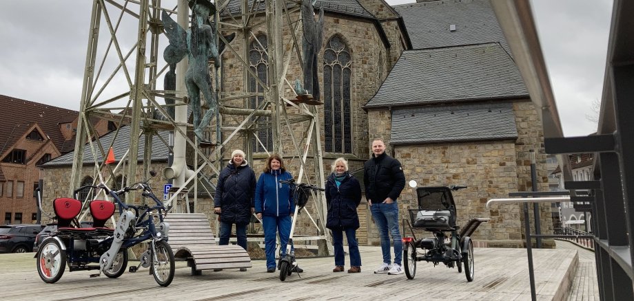 Martina Niehoff und Martina Röttger-Hölscher (DRK-Generationenbüro), Martina Witzig (Stadt Gronau) und Jeremias Rotthäuser (DSPN GmbH) stehen mit ihren Rädern an der Rückseite der St. Antonius-Kirche in Gronau. Bei ihrer Rundfahrt besuchten sie verschiedene Lebensbereiche und verschafften sich einen Eindruck in Bezug auf die Gesundheitsförderung und Prävention in Gronau