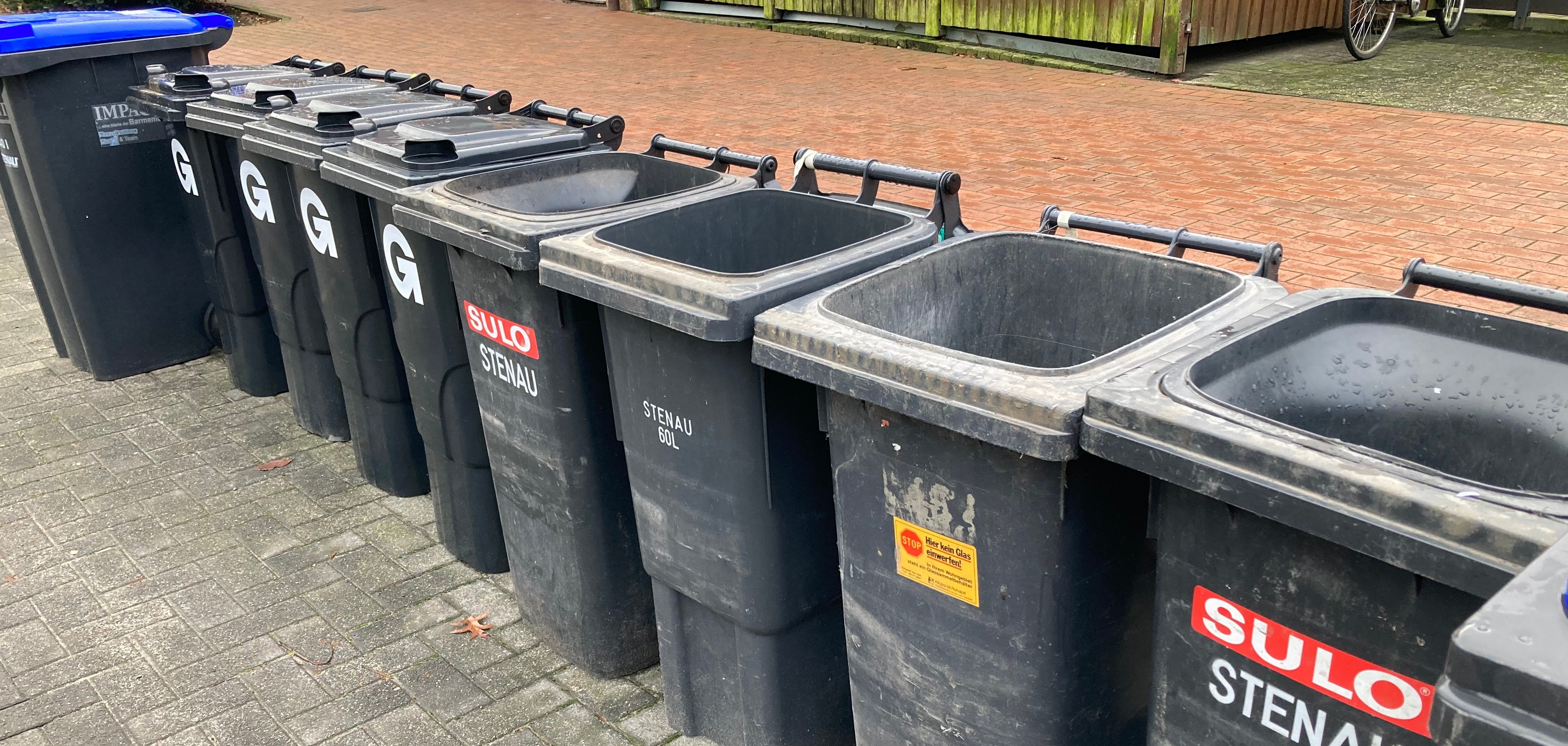 Graue Mülltonnen mit offenem und geschlossenen Deckel