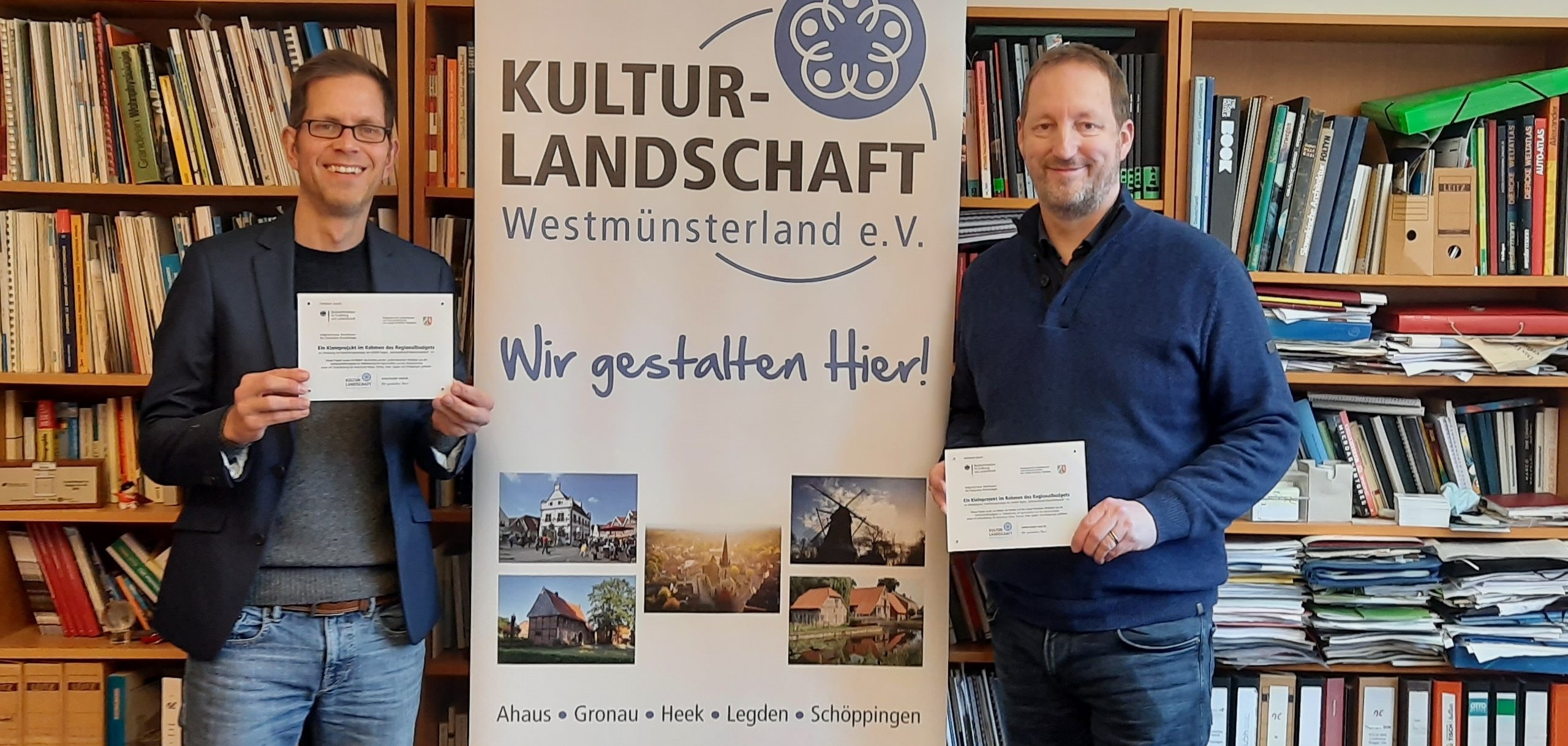 Dominik Olbrich und Dr. Frank Bröckling stehen vor einem großen Buchregal freuen sich auf neue Ideen aus der Region im Regionalbudget 2024