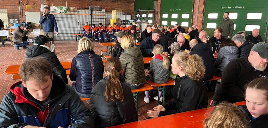 Viele der Freiwilligen, die sich an der 22. Müllsammelaktion in Gronau beteiligt haben sitzen in der Halle der Zentralen Bau- und Umweltdienste und genießen nach getaner Arbeit den Imbiss.   