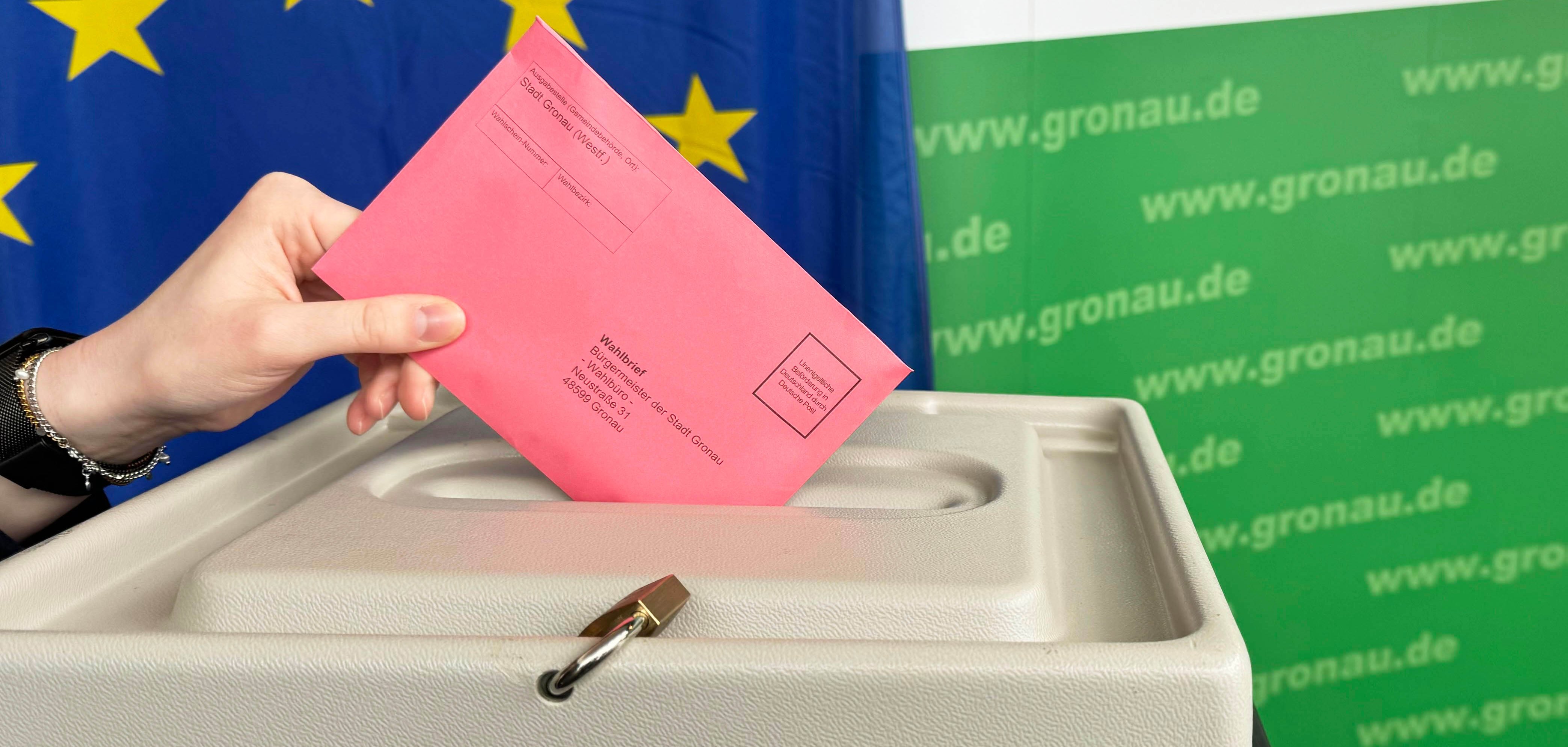 Ein roter Wahlbrief für die Europarwahl wird in eine Wahlurne geworfen.