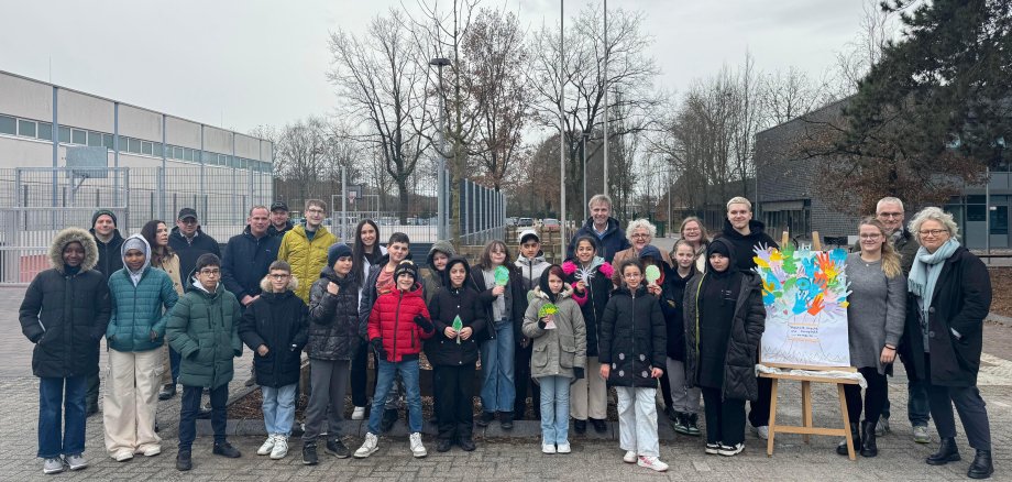 Bürgermeister Rainer Doetkotte, Stadtbaurat Ralf Groß-Holtick, Erste Beigeordnete Christiane Schrader sowie Schulleiterin Frau Steuer und Schüler:innen der Gesamtschule und weiteren Projektbeteiligten vor dem neuen Schulhof.