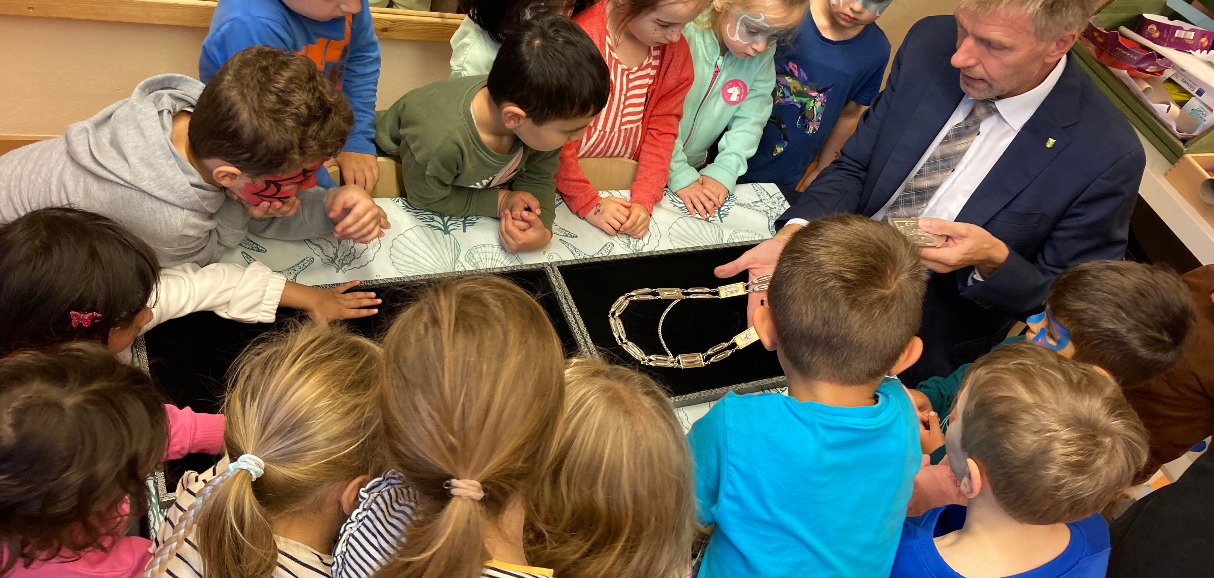 Die Kinder der Kita Janosch bestaunen die Bürgermeisterkette von Bürgermeister Rainer Doetkotte.