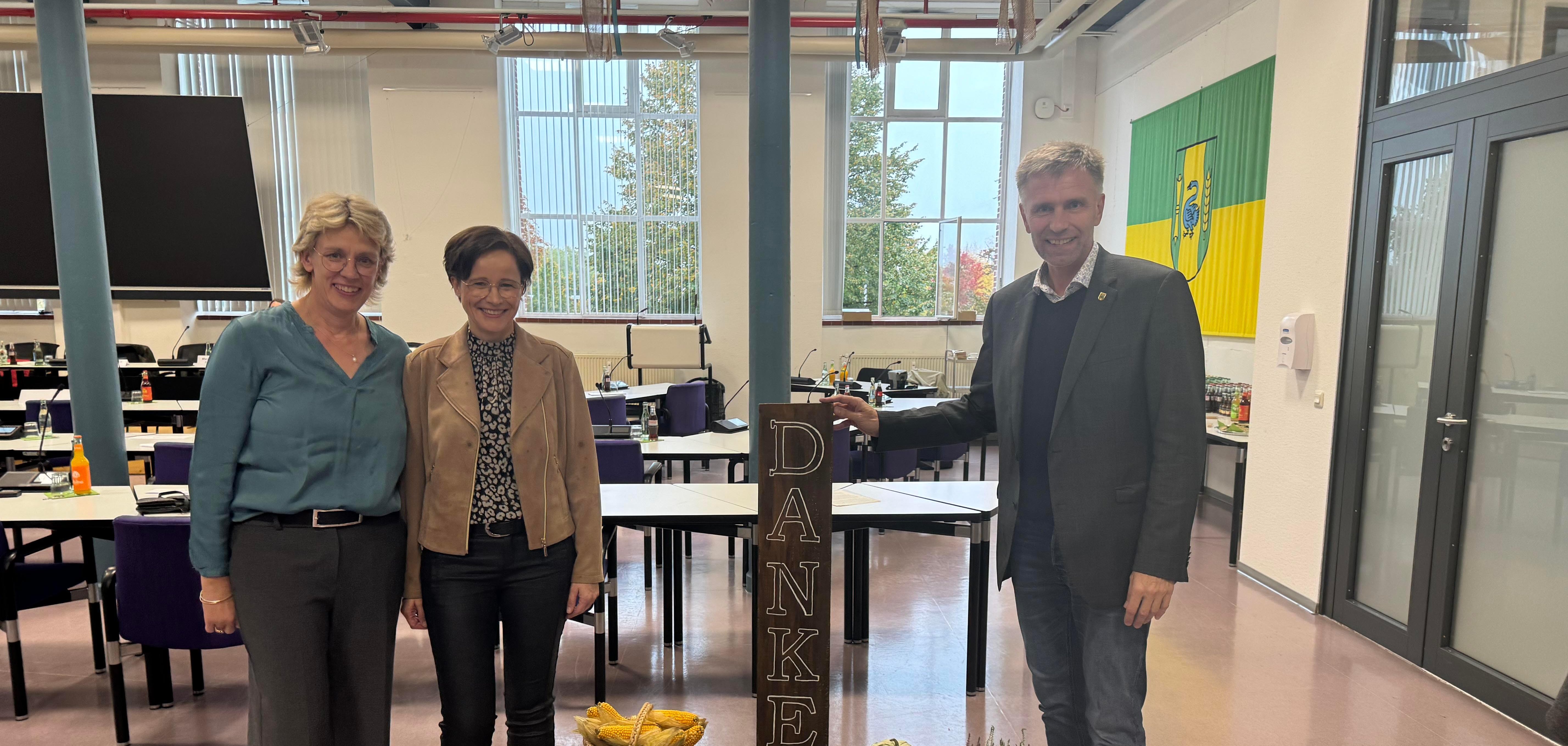 Sigrid Vornholt, Teamsprecherin des Kreisvorstands der Landfrauen, Mechthild Schlamann, Teamsprecherin der Landfrauen Epe/Gronau und Bürgermeister Rainer Doetkotte vor der Erntekrone im Ratssaal in Gronau.