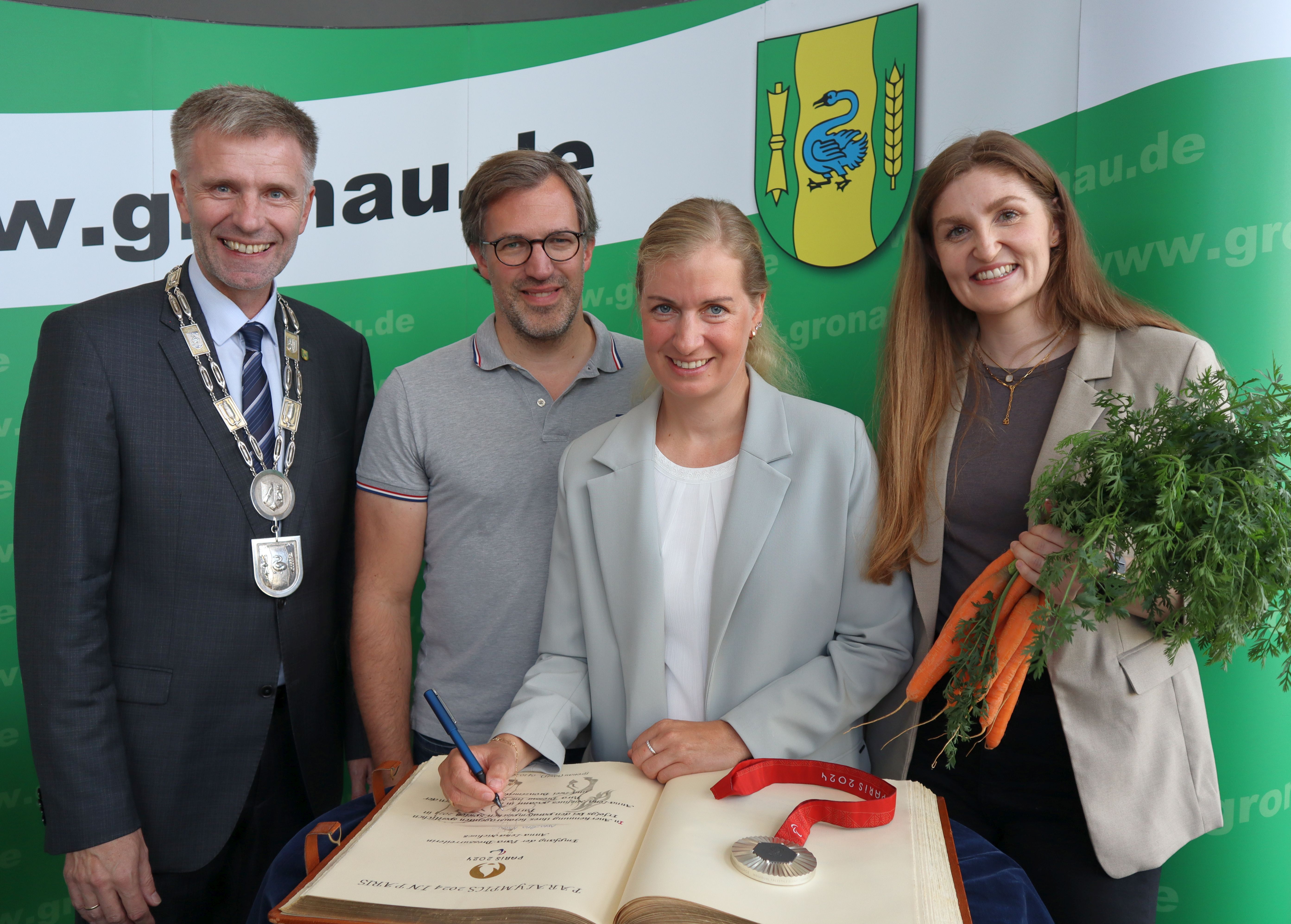Die Paralympicssiegerin Anna-Lena Niehues mit weiteren Personen bei der Eintragung in das Goldene Buch