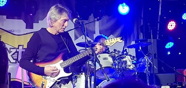Jan le Loux mit einer Gitarre auf einer Bühne