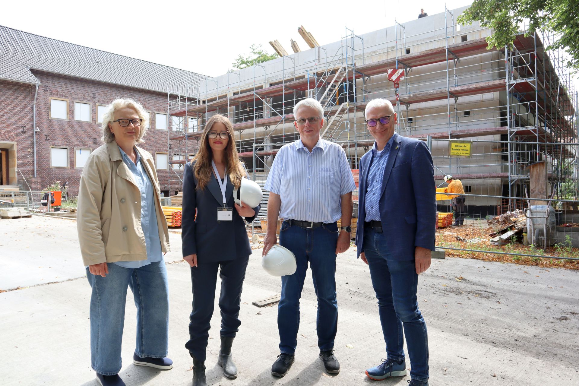 Erste Beigeordnete Christiane Schrader, Wilma Karakac, Thomas Brunnert von der Stadt Gronau und Stadtbaurat Ralf Groß-Holtick vor der Baustelle an der Fridtjof-Nansen-Realschule.