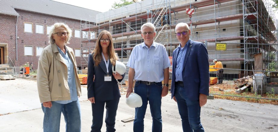 Erste Beigeordnete Christiane Schrader, Wilma Karakac, Thomas Brunnert von der Stadt Gronau und Stadtbaurat Ralf Groß-Holtick vor der Baustelle an der Fridtjof-Nansen-Realschule.
