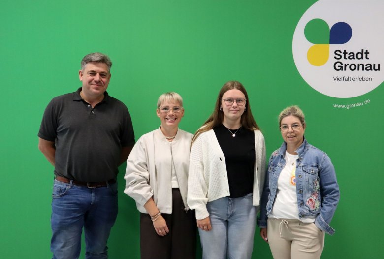 Die Kita-Leitungen Rita Heitkamp und Oliver Hildering mit den neuen Auszubildenden für den Beruf der Erzieherinnen vor der Fotoowand mit dem Logo der Stadt Gronau Die Kita-Leitungen Rita Heitkamp und Oliver Hildering mit den neuen Auszubildenden für den Beruf der Erzieherinnen