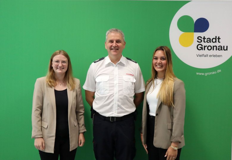 Der stellvertende Leiter der Feuer- und Rettungswache mit den neuen Auszubildenden für den Beruf der Notfallsanitäterinnen vor der Fotowand mit dem Logo der Stadt Gronau Der stellvertende Leiter der Feuer- und Rettungswache mit den neuen Auszubildenden für den Beruf der Notfallsanitäterinnen vor der Fotowand mit dem Logo der Stadt Gronau