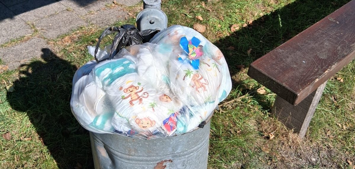 Überfüllter Abfallbehälter auf einem Spielplatz