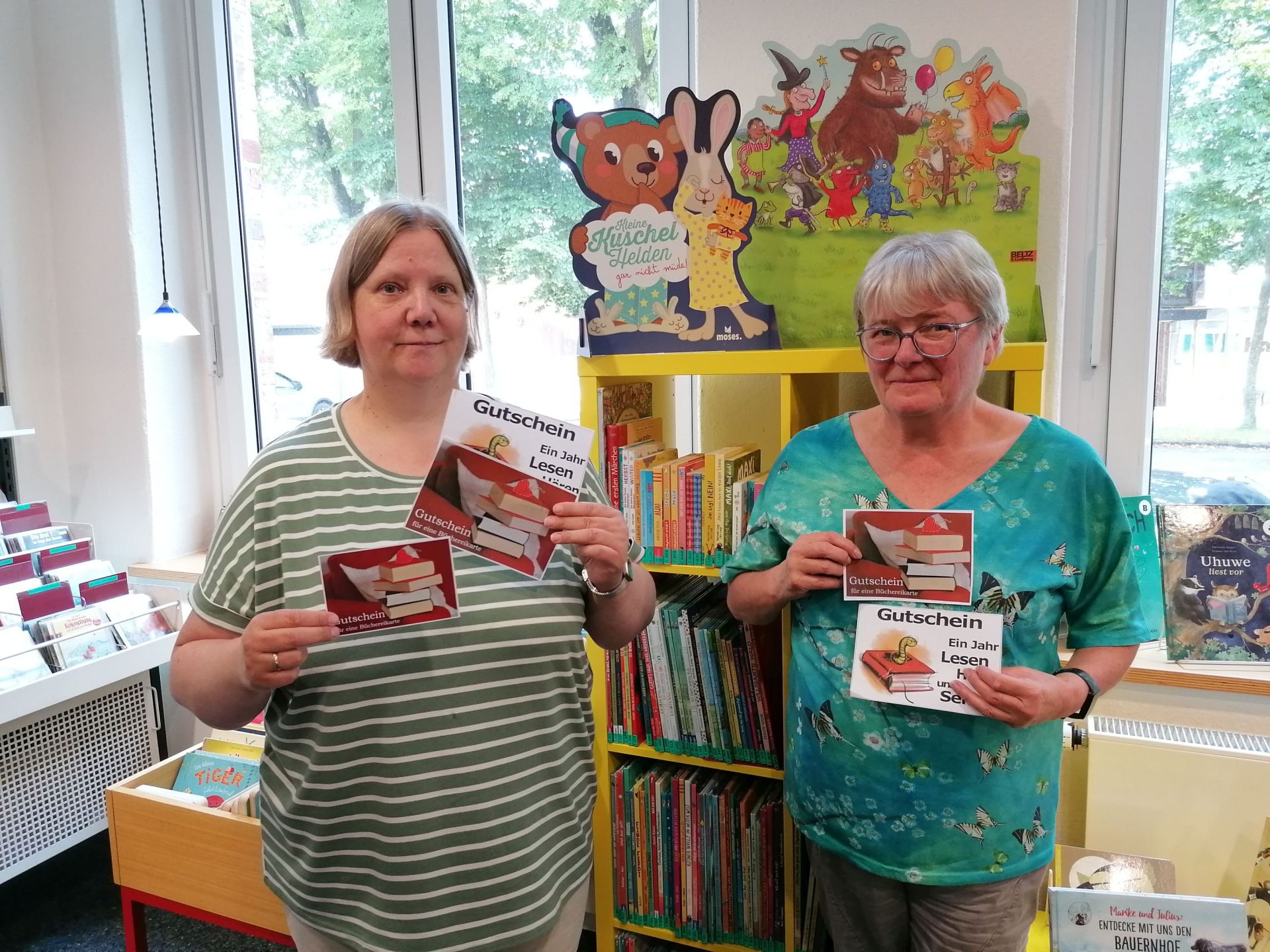 Die Mitarbeiter:innen verteilen Gutscheine an die Erstklässer:innen.