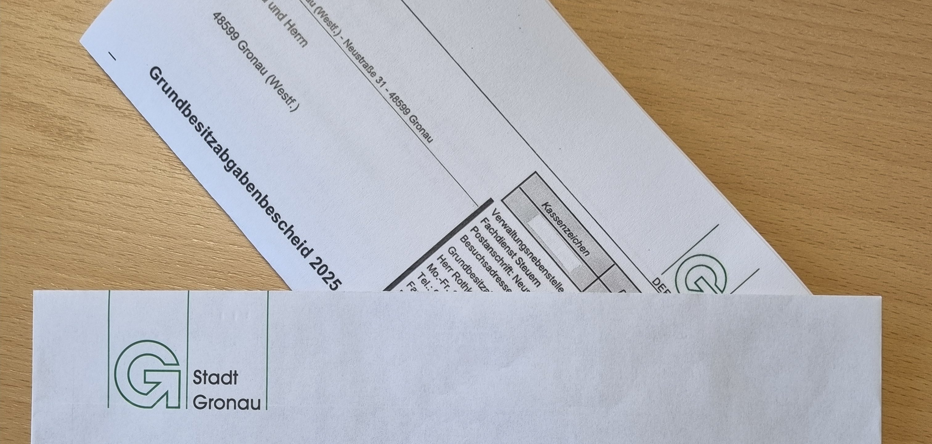 Ein Grundbesitzabgabenbescheid in einem Briefumschlag.