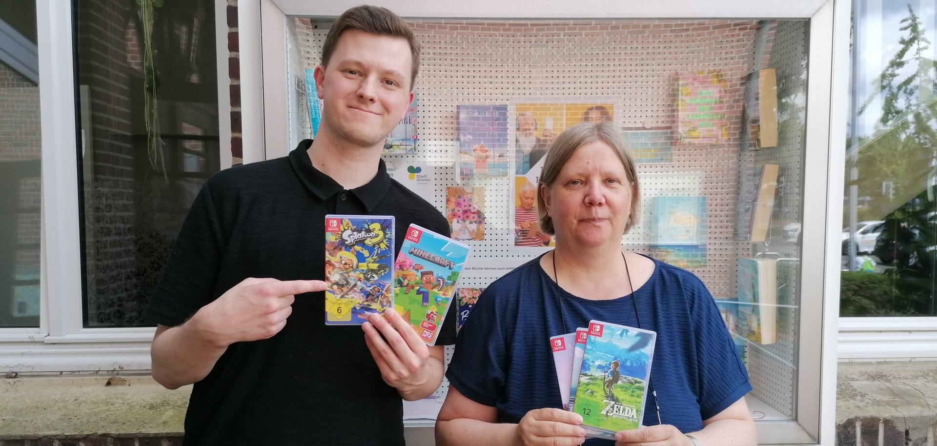 Mitarbeitende der Stadtbücherei Gronau präsentieren die angebotenen Switch-Spiele